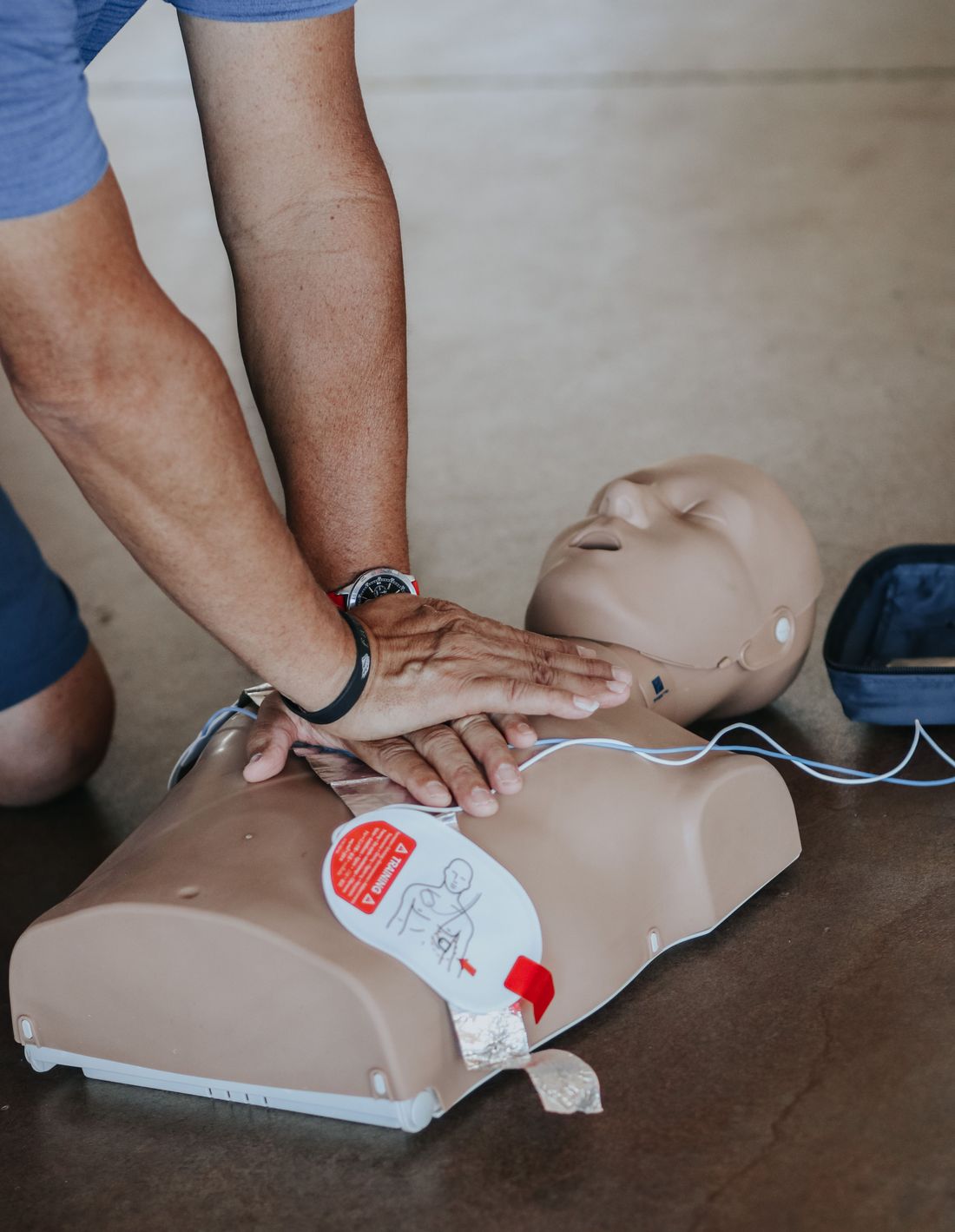 Hands-on CPR training with AED pads on a manikin